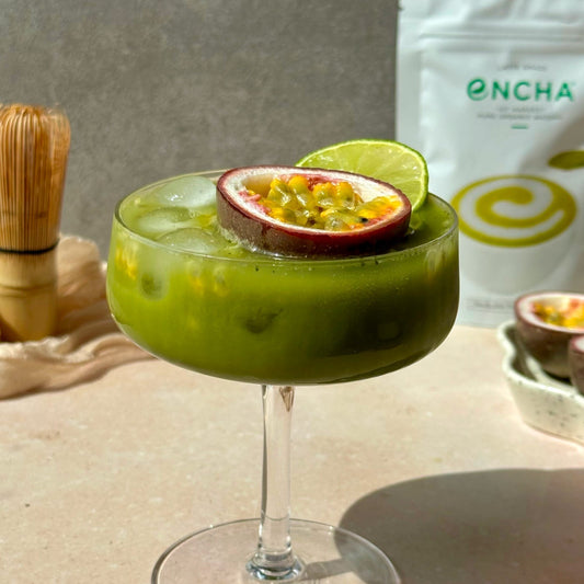 Glass of tropical Passionfruit Sparkle Matcha with ice and fresh passionfruit garnish