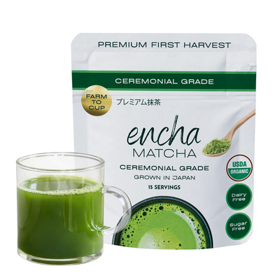 A stand-up pouch of Encha Matcha ceremonial grade matcha tea next to a clear glass mug filled with green matcha tea, on a plain white background. _30g (1.06oz) 15 cups