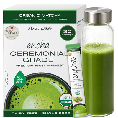 A box of Encha Ceremonial Grade organic matcha tea alongside a clear glass bottle filled with brewed green matcha and a single stick pack, on a white background. _Single serve sticks 30 pack