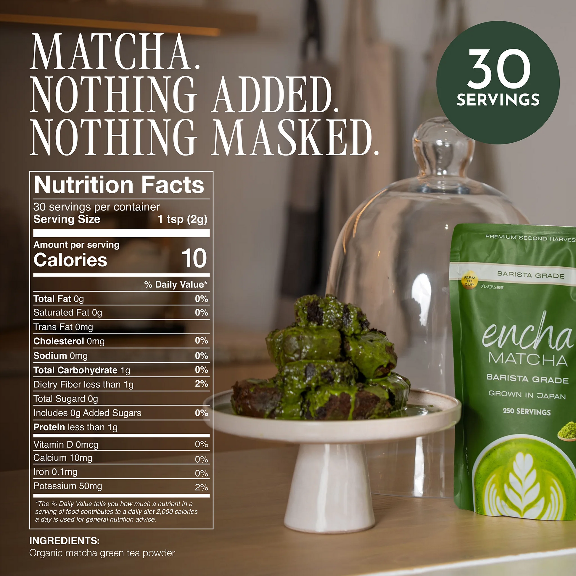 A green tea powder pouch labeled 'encha MATCHA BARISTA GRADE' sits on a white pedestal next to a glass cloche holding matcha green tea cakes, with a large Nutrition Facts panel and marketing text in the background. __60g (2.12 oz) 30 cups